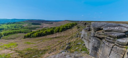 Foto de Una vista panorámica mirando hacia atrás a lo largo de la escarpa Stanage Edge en el Peak District, Reino Unido en verano - Imagen libre de derechos