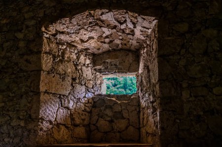 Téléchargez les photos : Une vue vers une fenêtre dans le donjon des ruines du château de pierre à la périphérie de la ville de Begunje na Gorenjskem, Slovénie en été - en image libre de droit