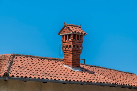 Photo for A view towards a roof and chimney stack in the town of Piran, Slovenia in summertime - Royalty Free Image
