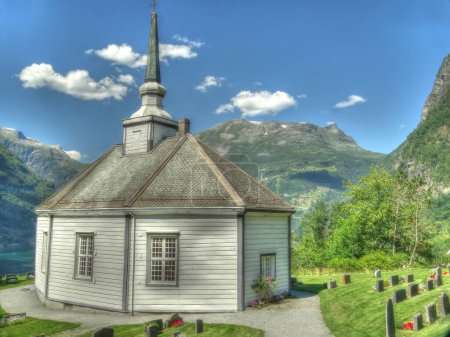 Téléchargez les photos : Vue vers une église en bois au-dessus du Geirangerfjord en Norvège en été - en image libre de droit