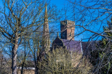 Téléchargez les photos : Une vue à travers les arbres vers l'église Sainte-Marie et Saint-Nicolas à Spalding, Lincolnshire par une journée ensoleillée - en image libre de droit