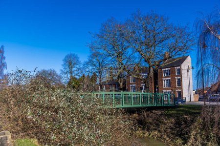 Téléchargez les photos : Une vue vers une passerelle sur la rivière Welland en face de Welland Place dans le centre de Spalding, Lincolnshire par une journée ensoleillée - en image libre de droit