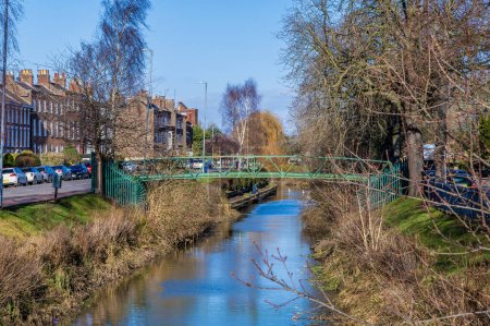 Téléchargez les photos : Une vue le long de la rivière Welland vers un pont tubulaire dans le centre de Spalding, Lincolnshire par une journée ensoleillée - en image libre de droit