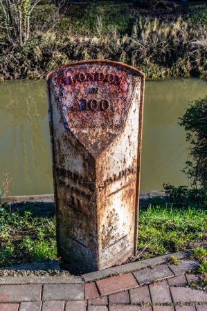 Photo for A view of a milestone beside the bank of the River Welland opposite Welland Place in Spalding, Lincolnshire on a bright sunny day - Royalty Free Image