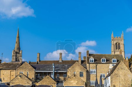 A view across the rooftops towards All Saints and Saint Johns Churches in Stamford, Lincolnshire, UK in springtime
