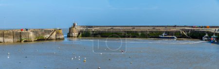 A panorama view across the harbour at low tide in Saundersfoot, Wales on a bright spring day