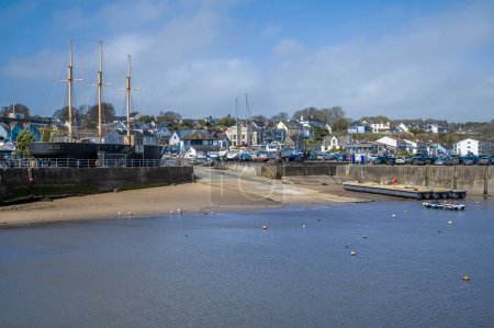 A view along the inner harbour wall and slipway at low tide in Saundersfoot, Wales on a bright spring day