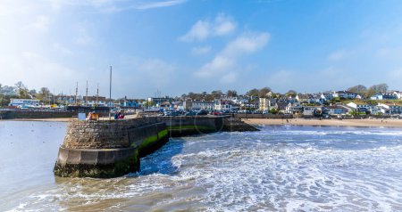 A view towards the harbour wall as the tide turns in the village of Saundersfoot, Wales on a bright spring day