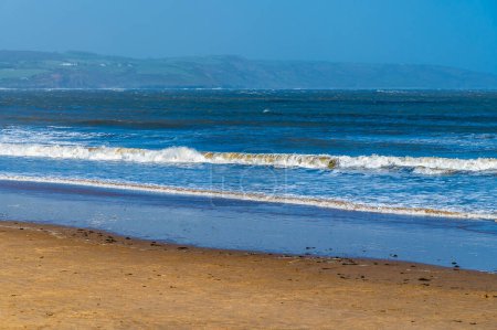 A view out to sea from the beach in the village of Saundersfoot, Wales on a bright spring day