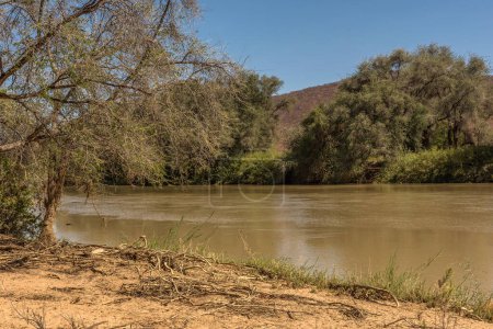Téléchargez les photos : Paysage sur les rives de la rivière Kunene, la rivière frontière entre la Namibie et l'Angola - en image libre de droit