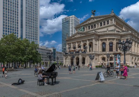 Foto de FRANKFURT AM MAIN, ALEMANIA-14 DE JULIO DE 2023: Joven pianista frente al Alte Oper, Frankfurt, Alemania - Imagen libre de derechos