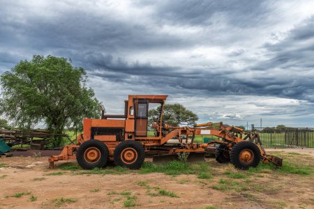 Photo for Orange grader parked on the side of a road, Namibia - Royalty Free Image