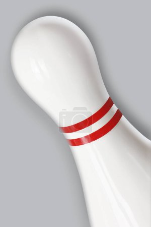 A close up of a ten pin bowling pin isolated on a grey background