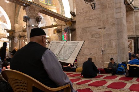 Foto de Jerusalén - Israel: 21 de abril de 2022. Hombre musulmán leyendo el Corán en la mezquita de Aqsa en Jerusalén - Imagen libre de derechos