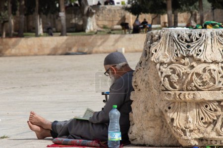 Téléchargez les photos : Vieil homme lisant le Coran dans la mosquée al-Aqsa - en image libre de droit