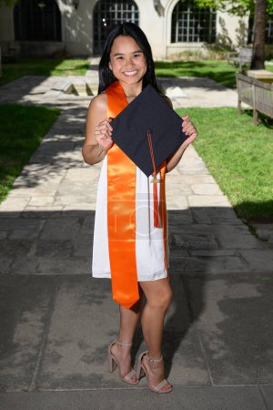 Photo for Young attractive Asian American girl with cap and gown preparing for college graduation - Royalty Free Image