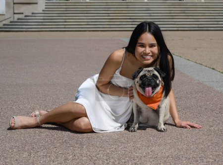 Photo for Young attractive Asian American girl with her pug dog preparing for college graduation - Royalty Free Image