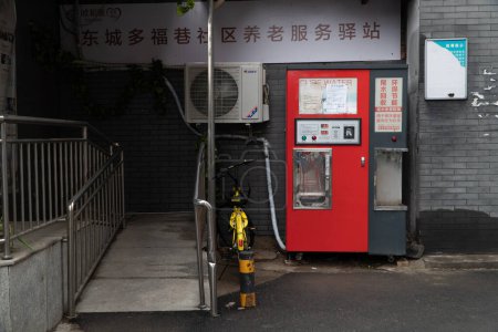 Téléchargez les photos : Photo horizontale d'un étal de rue fermé avec distributeur automatique et vélo jaune garé sur le côté, avec escalier. - en image libre de droit