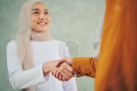 Téléchargez les photos : Femmes d'affaires musulmanes serrant la main après la conclusion des négociations commerciales. - en image libre de droit