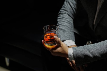 Téléchargez les photos : Des hommes d'affaires proches tenant un verre de whisky - en image libre de droit