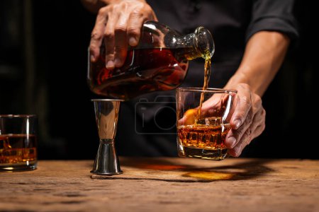 Téléchargez les photos : Barman Servir Whiskey, sur un bar en bois, - en image libre de droit