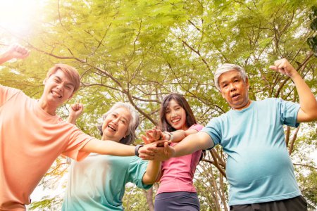 Téléchargez les photos : Famille asiatique heureuse : parents et fils et filles unissent leurs efforts pour exercer une énergie pour des esprits sains et heureux dans le parc. - en image libre de droit