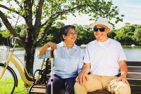 Photo for Senior couple asian caring for blind lovers concept : Happy senior wife was beside the blind old man and cared for him with loving support as he rested in the garden. - Royalty Free Image