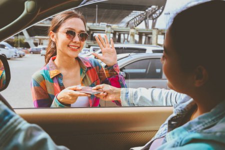 Good luck : Close female friend drove car drop off her beautiful female friend at the airport and handed her passport board the plane safely : Young asian women travel to study or work abroad.