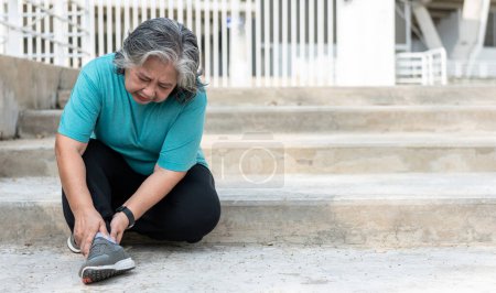 Téléchargez les photos : Femme âgée asiatique, souffre actuellement d'une blessure à la cheville pendant son exercice en courant dans les escaliers, en raison de l'arthrose, du sport et du concept de soins de santé. - en image libre de droit