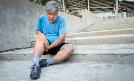 Foto de Asiático anciano, actualmente está teniendo una lesión en la rodilla durante su ejercicio por correr en las escaleras, debido a la osteoartritis, a los deportes de edad avanzada y el concepto de atención de la salud. - Imagen libre de derechos