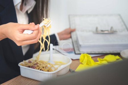 Foto de Business woman busy with work, where she eats while working because she hastened to complete the work according to the goal, to business and work so busy that you don't have time to eat concept - Imagen libre de derechos