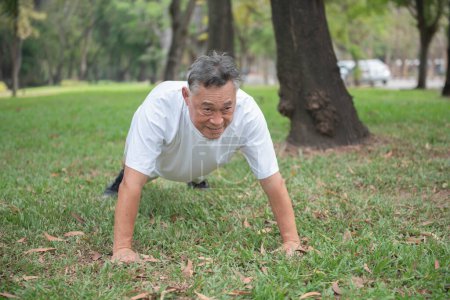 Téléchargez les photos : Homme asiatique âgé faisant push-ups dans un parc en plein air Idées d'exercice à la retraite - en image libre de droit