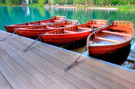 Holzboote an einem Steg an einem See festgemacht