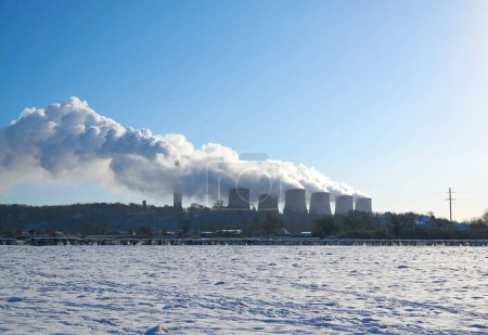 Photo for Power station cooling towers steaming during high demand in winter - Royalty Free Image