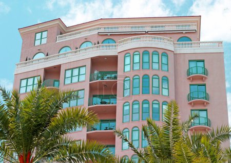 Foto de Un condominio tropical de estilo art déco con un cielo azul brillante y palmeras - Imagen libre de derechos