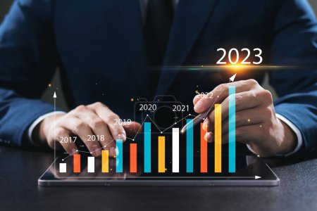 Geschäftsmann analysiert die Rentabilität arbeitender Unternehmen mit digitalen Augmented-Reality-Grafiken, positive Indikatoren im Jahr 2023, Geschäftsmann berechnet Finanzdaten für langfristige Investitionen.