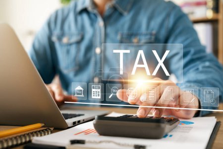 Foto de Corporate and individual tax payment concept, businessman using computer filling out corporate and personal income tax return, VAT and property tax of business. - Imagen libre de derechos