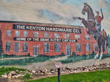 Foto de Kenton Hardware Company se convirtió en una de las fábricas de juguetes de hierro fundido más grandes del mundo. Famoso por la pistola de casquillo de juguete Gene Autrey. Este mural se encuentra en el centro de Kenton Ohio, Estados Unidos 2023. - Imagen libre de derechos