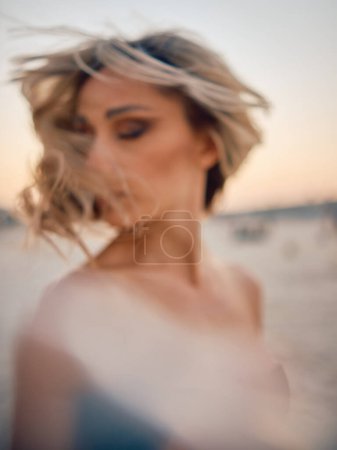 Photo for An artistic blur effect highlighting a mysterious woman with her hair tousled by wind - Royalty Free Image