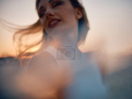 Téléchargez les photos : Image artistique floue capturant l'essence d'une femme insouciante lors d'un coucher de soleil pittoresque - en image libre de droit