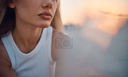 Photo for An unidentifiable woman gazing towards a sunset, her face artistically obscured inviting mystery and contemplation - Royalty Free Image