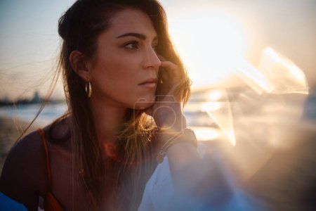 Photo for Close-up of woman's contemplative expression with a creative sun glare adding to the mood - Royalty Free Image