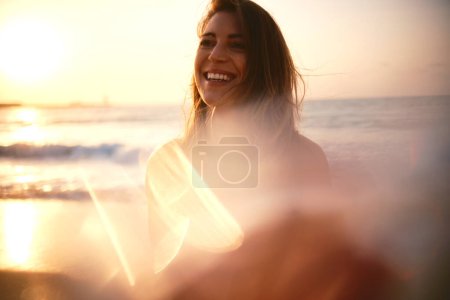 Eine entzückend lächelnde Frau mit Sonnenbrille erhellt die Strandszene