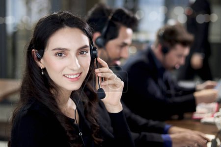 Portrait smiling beautiful woman black suit work at call center service desk consultant with teammate colleague, customer service executive with microphone headset use computer for supporting client