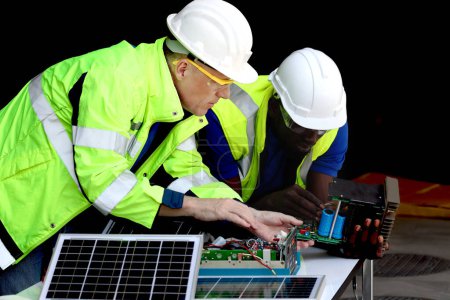 Photo for Two electrical engineers working with electronic circuit board and solar cells, mechanicals senior white and African American men working together, Happy diversity harmony people. - Royalty Free Image