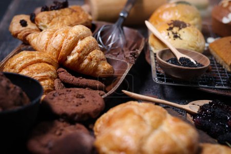 Sweet pastries, fresh baked butter breakfast croissants with sourdough and Danish pastry, puff pastry, breads and many desserts on wood table, delicious homemade bakery concep