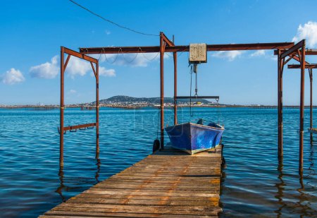 Téléchargez les photos : Un bateau à huîtres amarré sur un ponton, sur l'Etang de Thau et en arrière-plan le Mont-Saint-Clair, en Occitanie, dans le sud de la France - en image libre de droit
