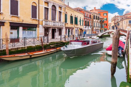 Téléchargez les photos : Bateaux et gondoles à quai, le long d'un canal, à Venise en Vénétie, Italie - en image libre de droit
