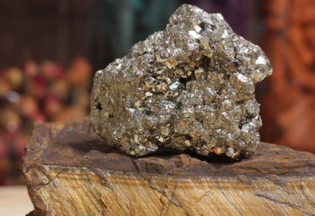 Foto de Pyrite Specimen on Raw Tigers Eye Rock With Dried Herbs in Background Shallow DOF - Imagen libre de derechos