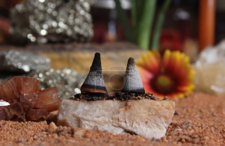 Téléchargez les photos : Cristal d'aragonite avec cônes d'encens sur la table de méditation australienne de sable rouge - en image libre de droit